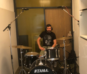 Marius sitzt am Schlagzeug und hrt ber Kopfhrer seine Aufnahmen